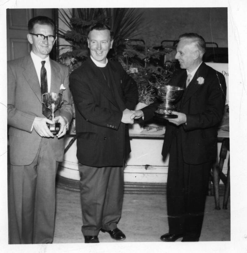 On the Right Mr H K Jeacock the Chairman presenting a trophy to the Reverend J J Broadhurst, Vicar of St Peter's Church. The gentleman on the left is unknown